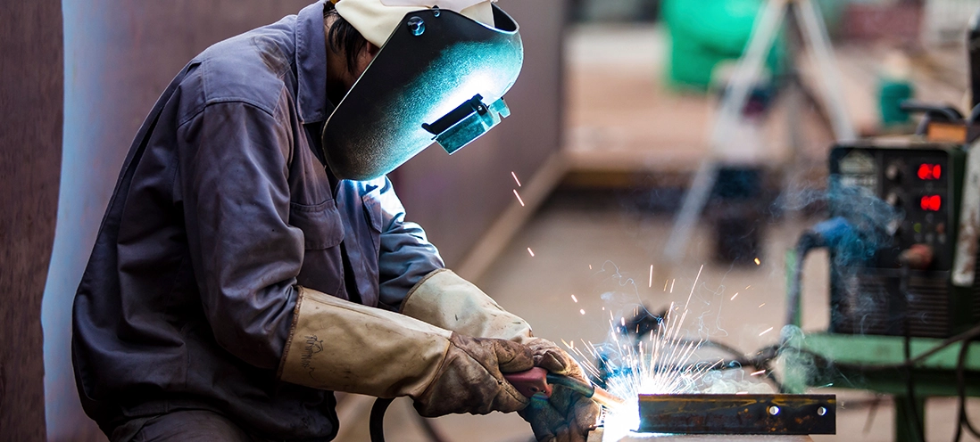 A person in welding safety equipment is welding.