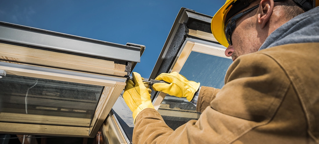 A construction worker working on a home's skylight.