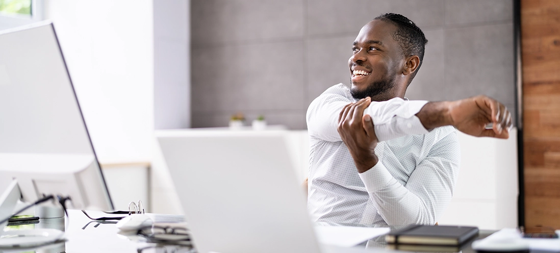 Man stretching at his desk.