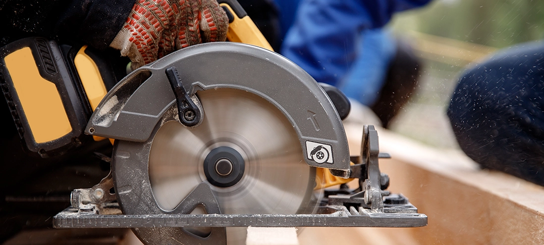 Person using circular saw.