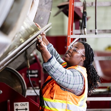 Woman working in metal fabrication shop.