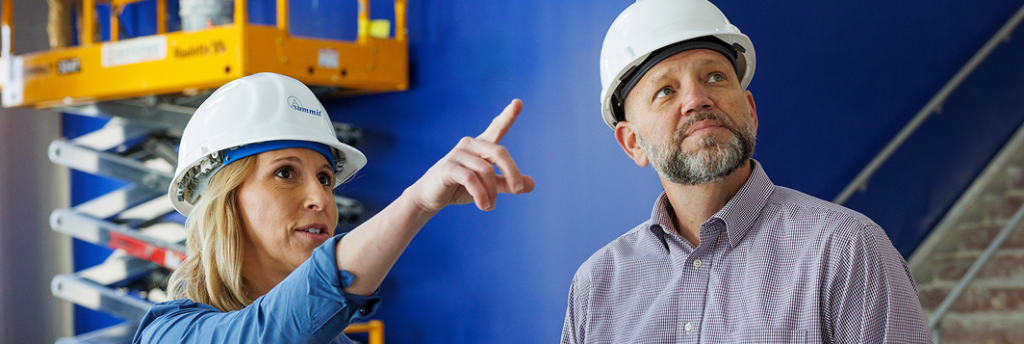 A Summit safety consultant in a hard hat gives instruction on a job site.